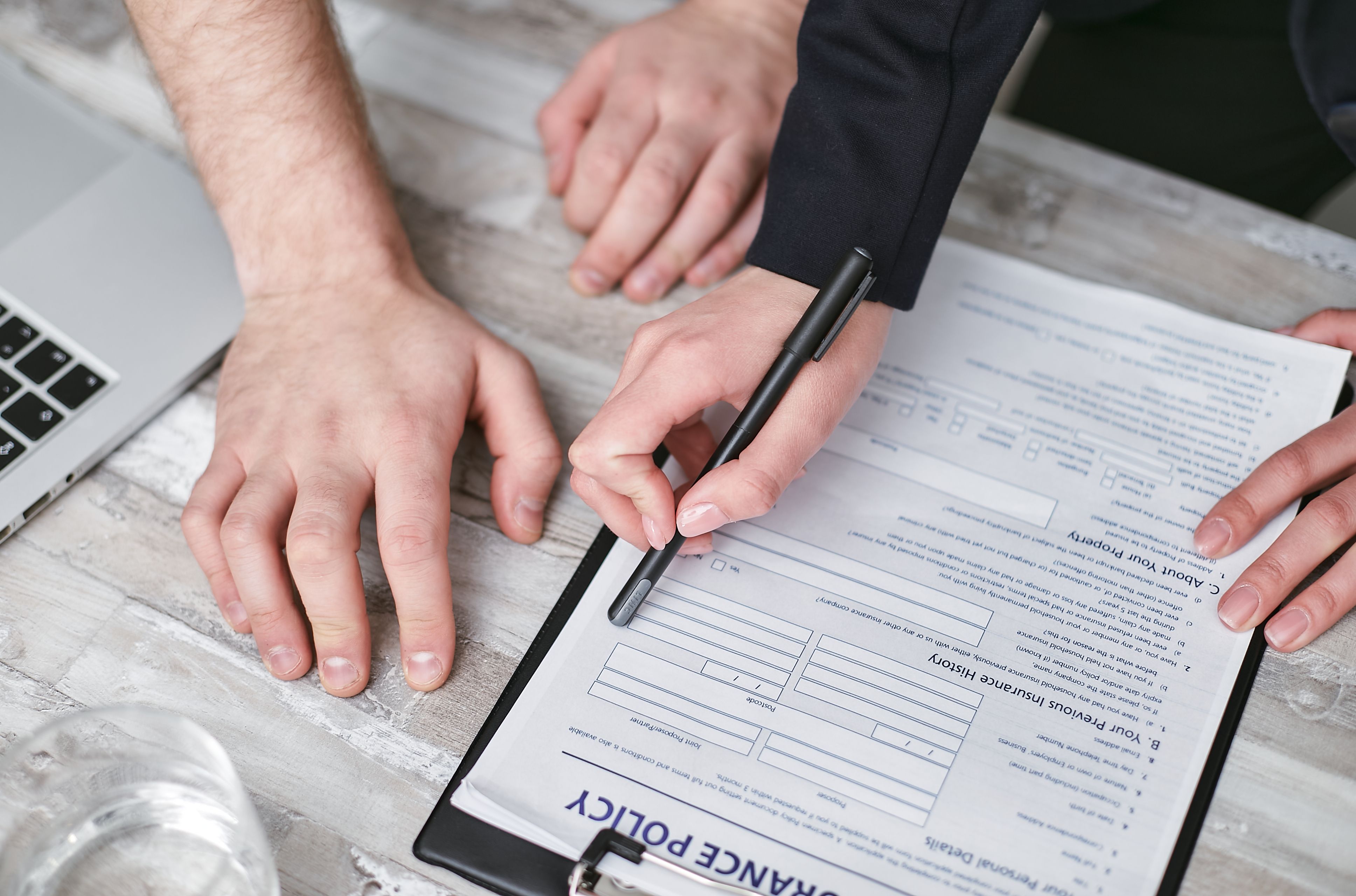 A person meticulously examining pet insurance policy documents, highlighting the importance of understanding terms and conditions before enrollment.